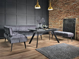Modern dining room with gray sofa, table, and chairs against a brick wall.