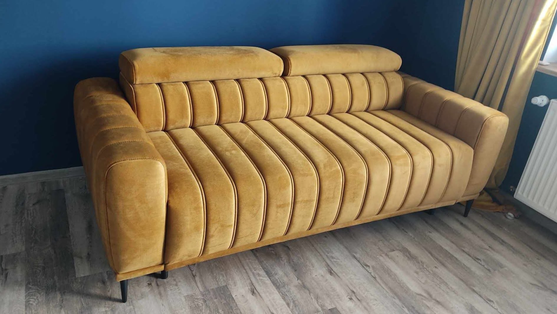 Brown sofa Gandi in a room with blue walls and a radiator.