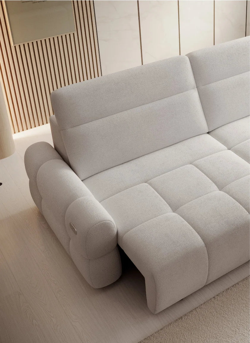 Gray sectional sofa Mateo in a minimalistic room with light-colored walls and floor.