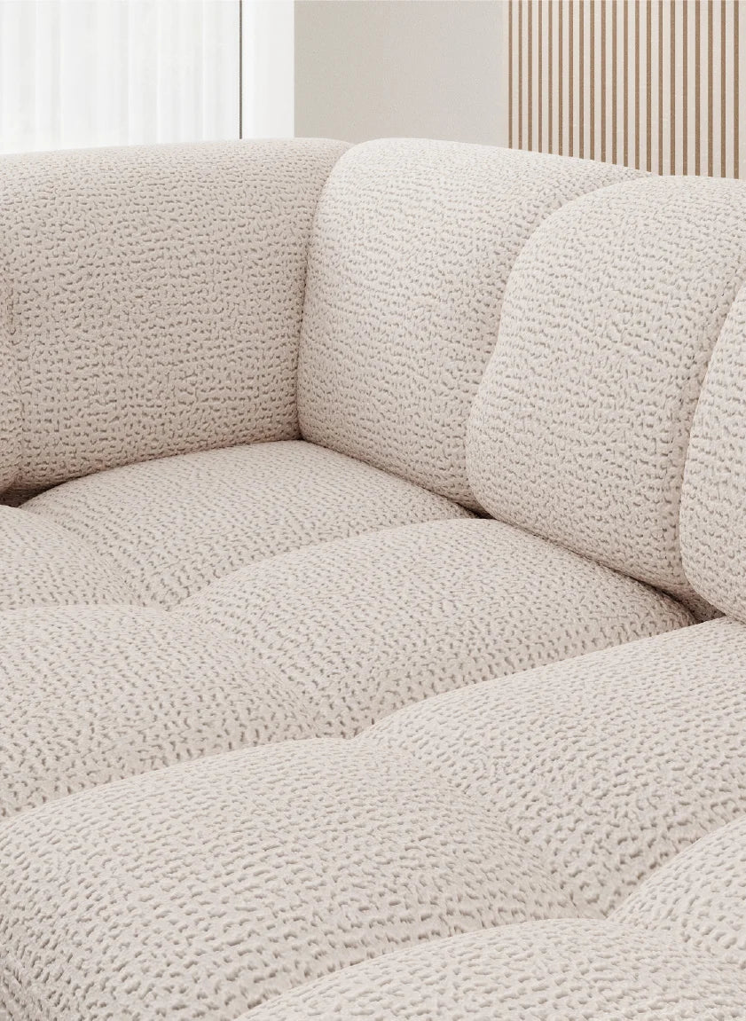 Close-up of a textured grey corner sofa VELPA L with electric seat adjustment in a neutral setting 