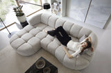Woman lying on a modern gray VELPA S sectional corner sofa in a bright living room. 