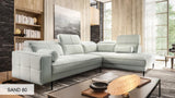 Light gray corner sofa Divano in a modern living room with bookshelf and artwork.